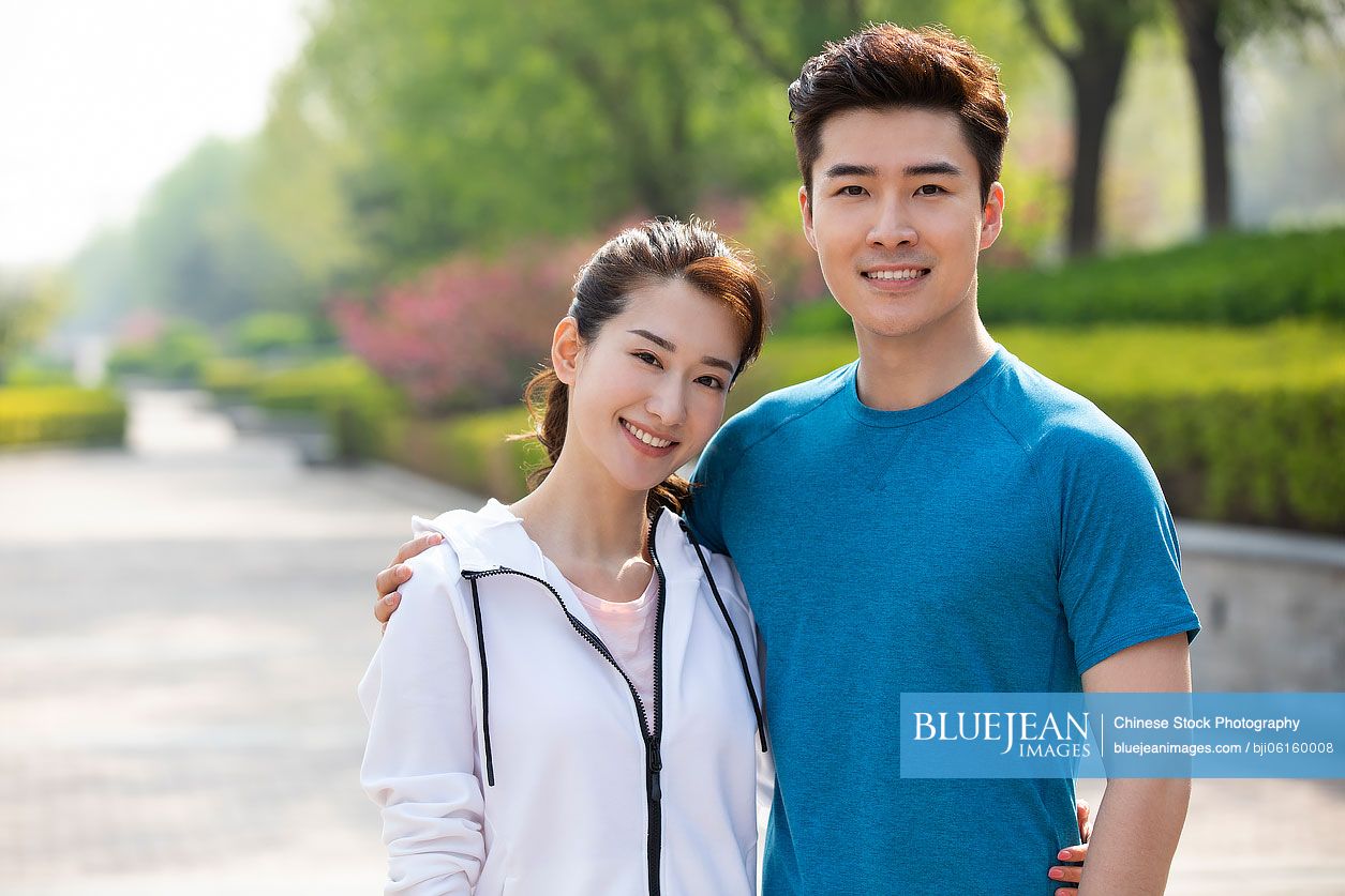 Happy young Chinese couple exercising in park