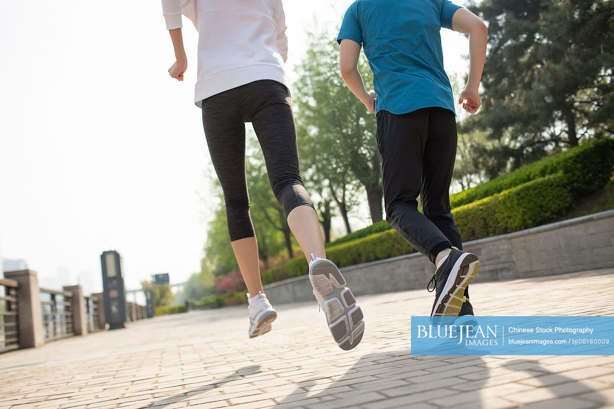 Young Chinese couple running in park