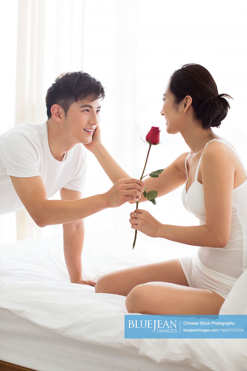 Happy young Chinese couple enjoying their love at home
