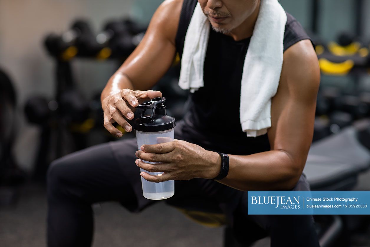 Mature Chinese man taking a break at gym