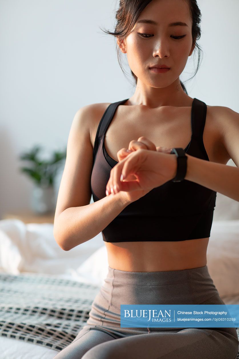Young Chinese woman checking smart watch