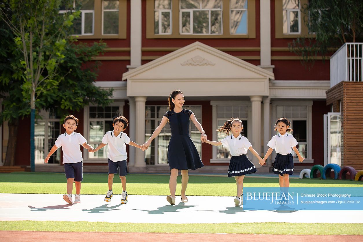 Chinese teacher and students in kindergarten playground