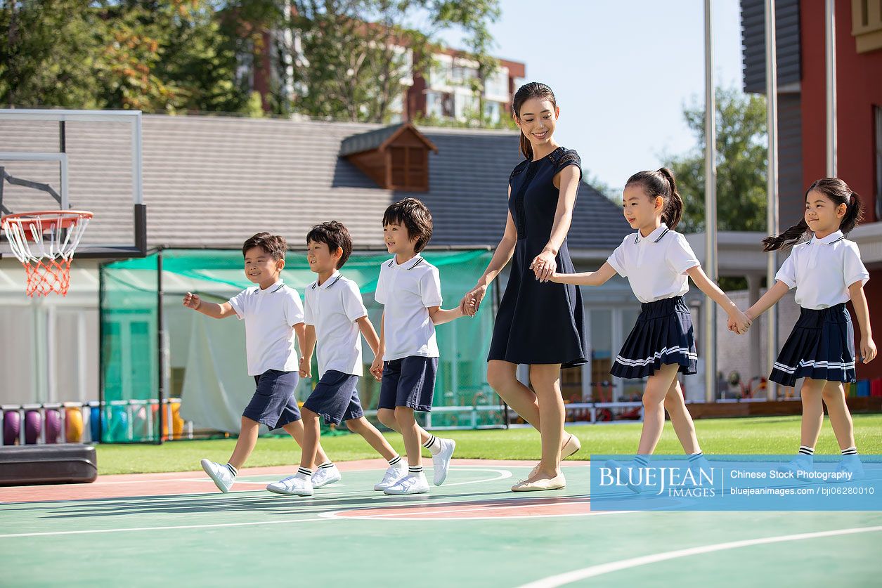 Chinese teacher and students in kindergarten playground