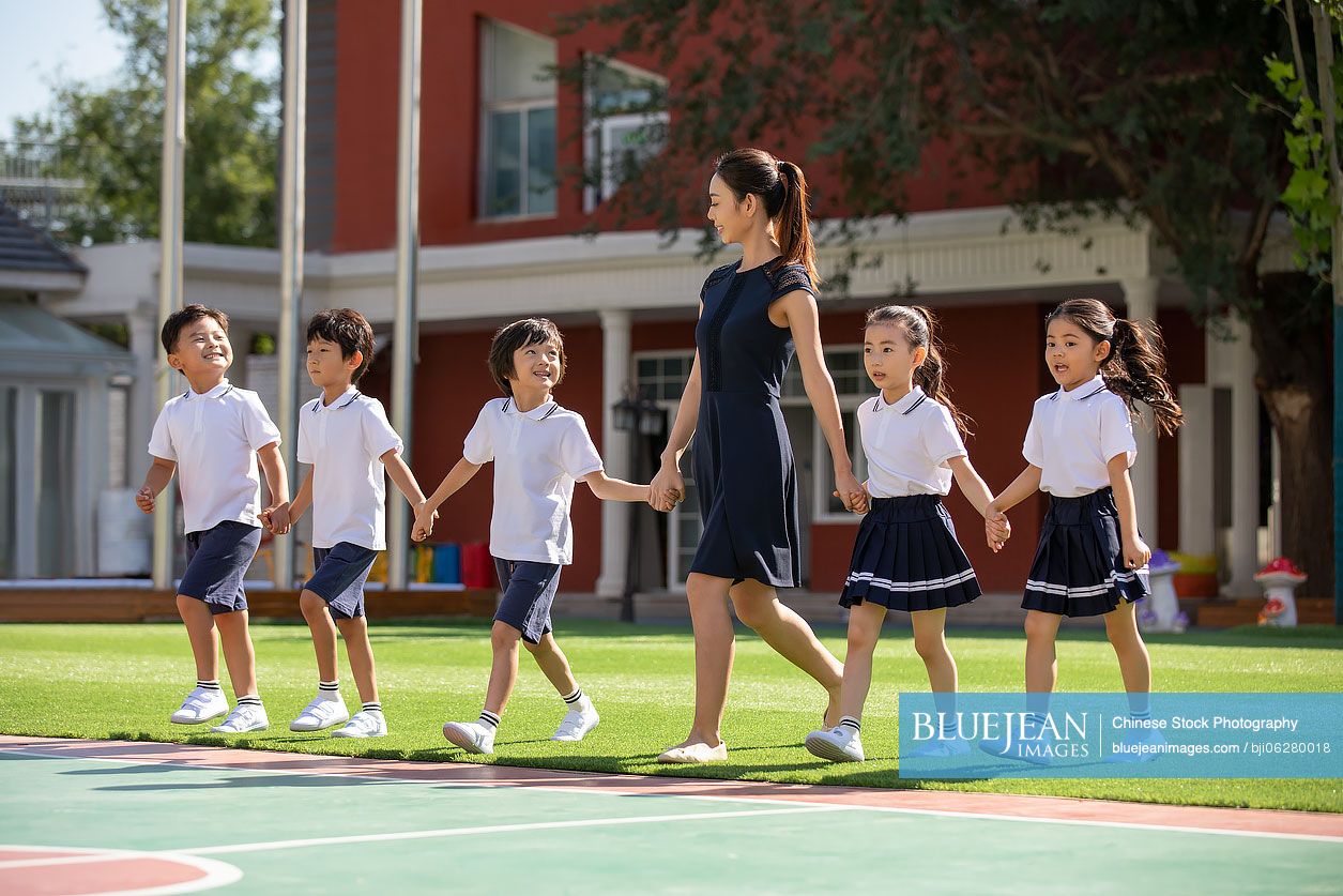 Chinese teacher and students in kindergarten playground