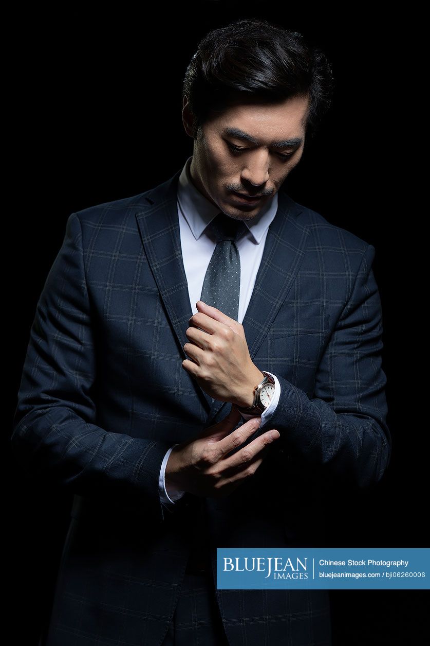 Successful Chinese businessman wearing wristwatch