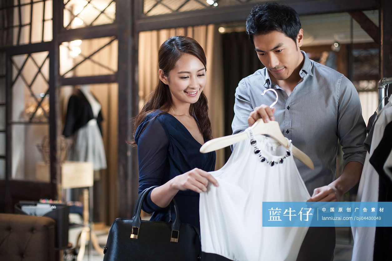 年轻夫妇在服装店挑选衣服