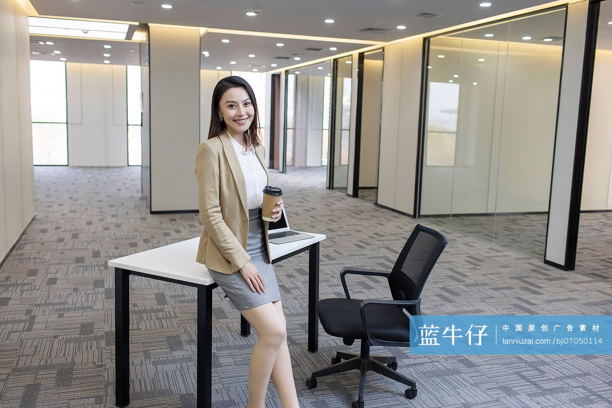 商务女士在空旷的办公室里喝咖啡