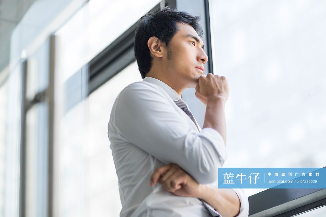 商务男士向办公室窗外望去