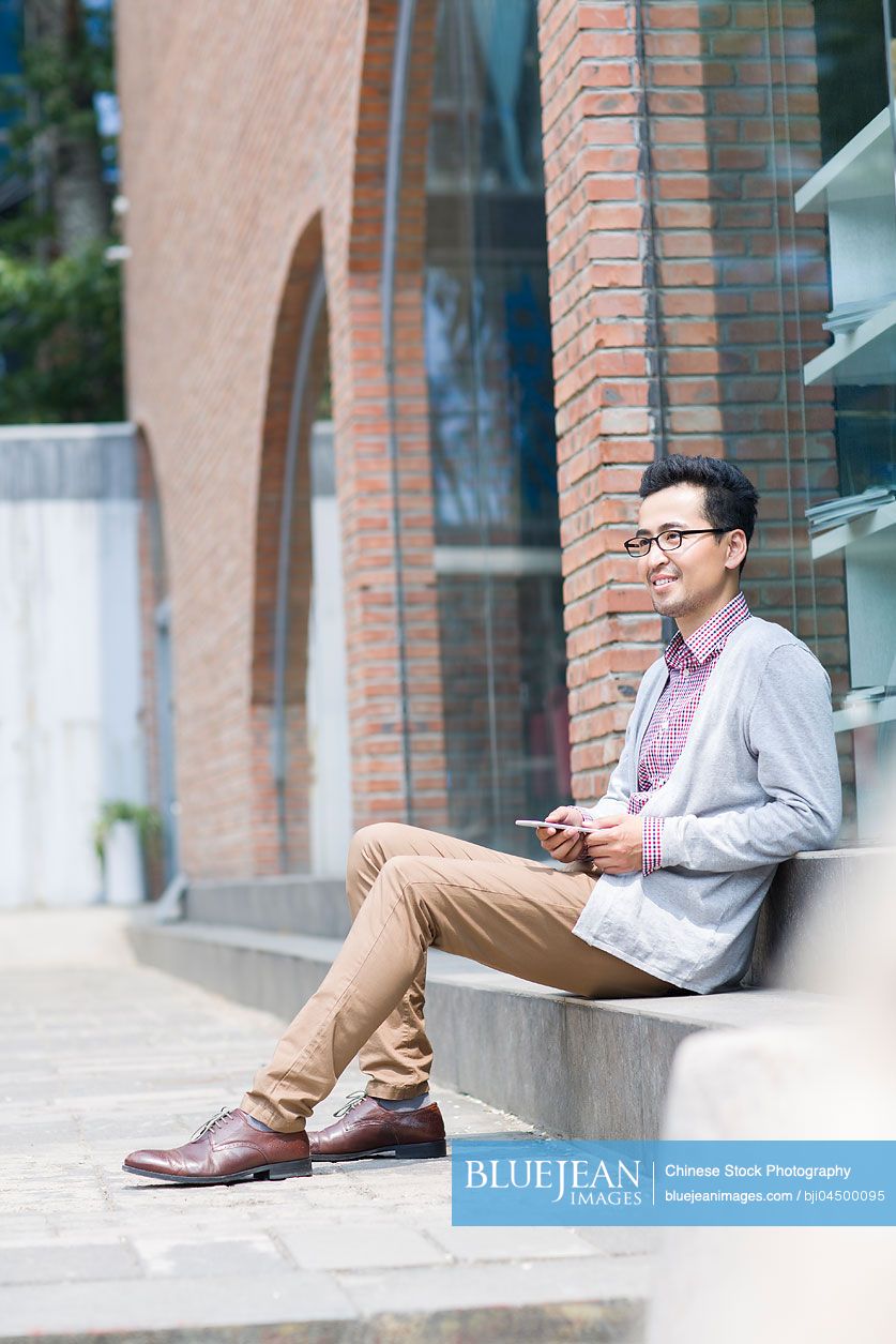 Chinese man holding a smart phone