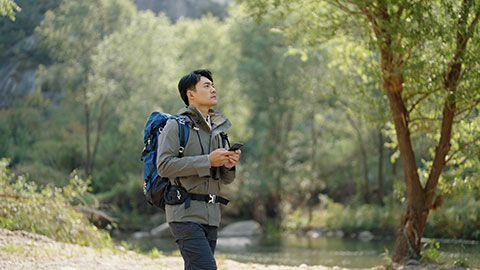 Young Chinese man hiking outdoors