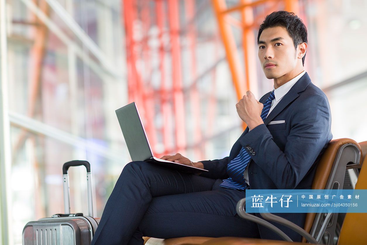 年轻商务男士在机场使用笔记本电脑