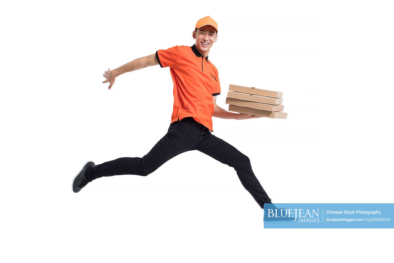 Cheerful Chinese pizza delivery person jumping