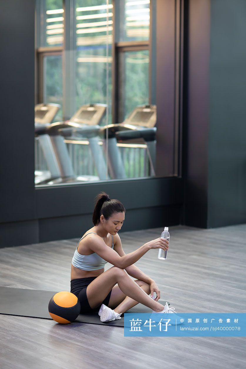 年轻女士在健身房休息