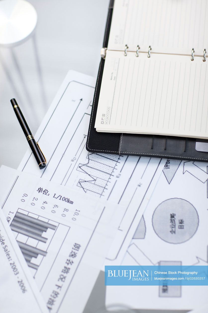 Notepad and business charts on desk