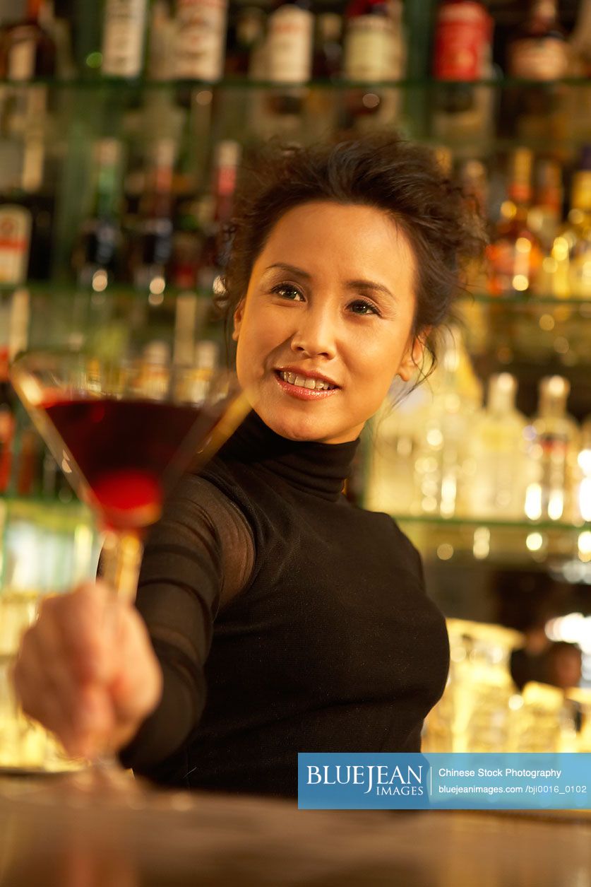 Chinese bartender serving cocktail