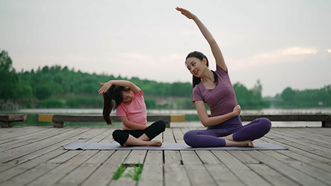 妈妈和女儿在公园练瑜伽