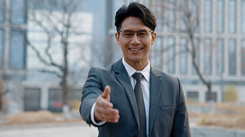 Confident Chinese businessman greeting outdoors