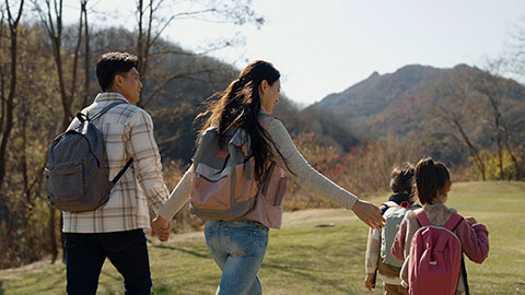 Happy young Chinese family hiking outdoors