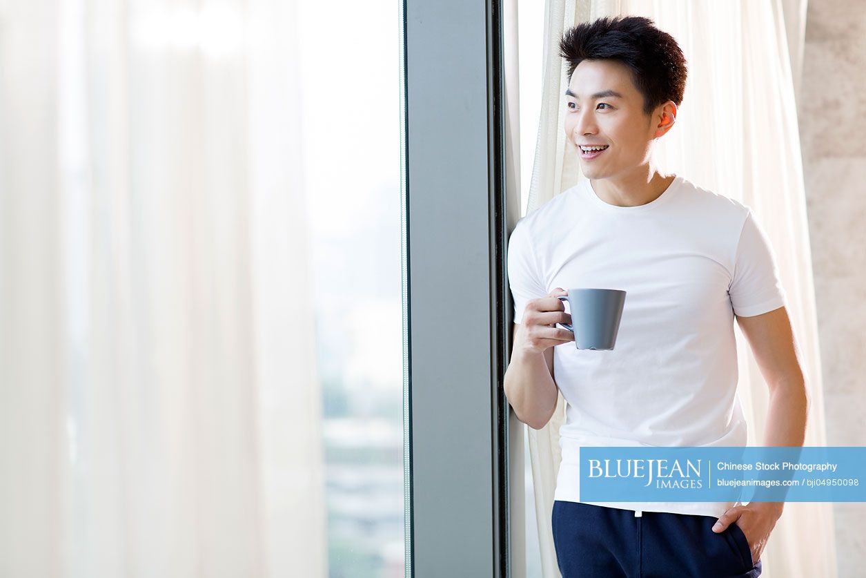 young-chinese-man-drinking-coffee-at-home-high-res-stock-photo-for-download
