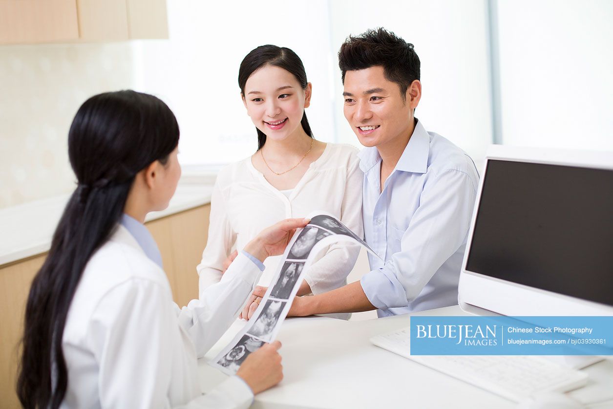 Pregnant Chinese woman and husband in doctor's office