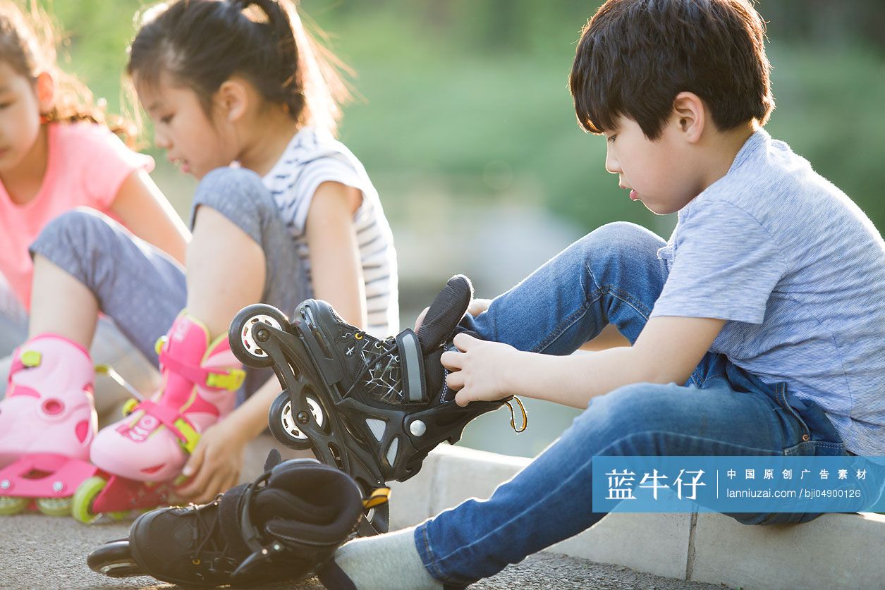 儿童坐在路边穿直排轮鞋