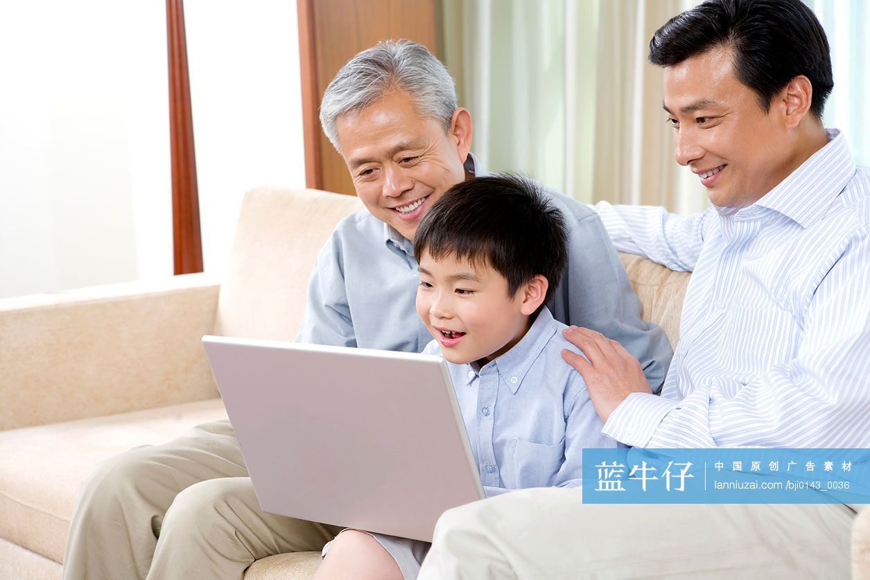 一家人在沙发上使用笔记本电脑