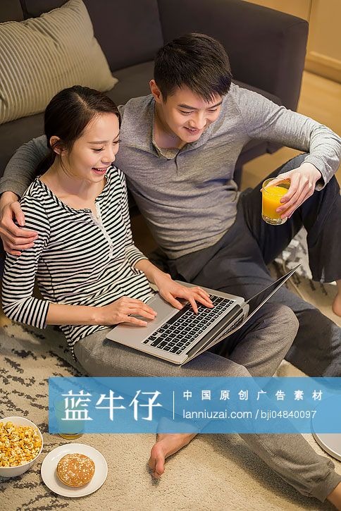 年轻情侣在客厅使用笔记本电脑-蓝牛仔影像-中国原创广告影像素材