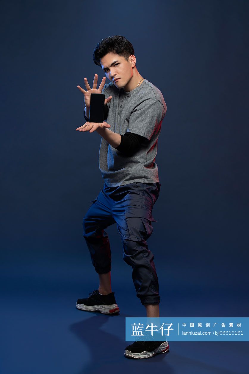 时尚的年轻男子展示手机