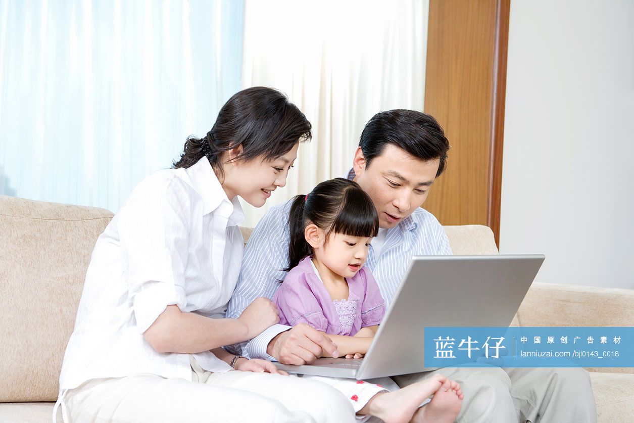 一家人在沙发上使用笔记本电脑