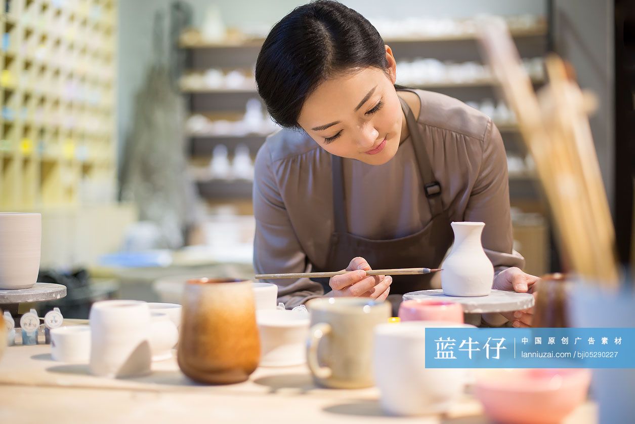 年轻陶艺师给陶胚上色