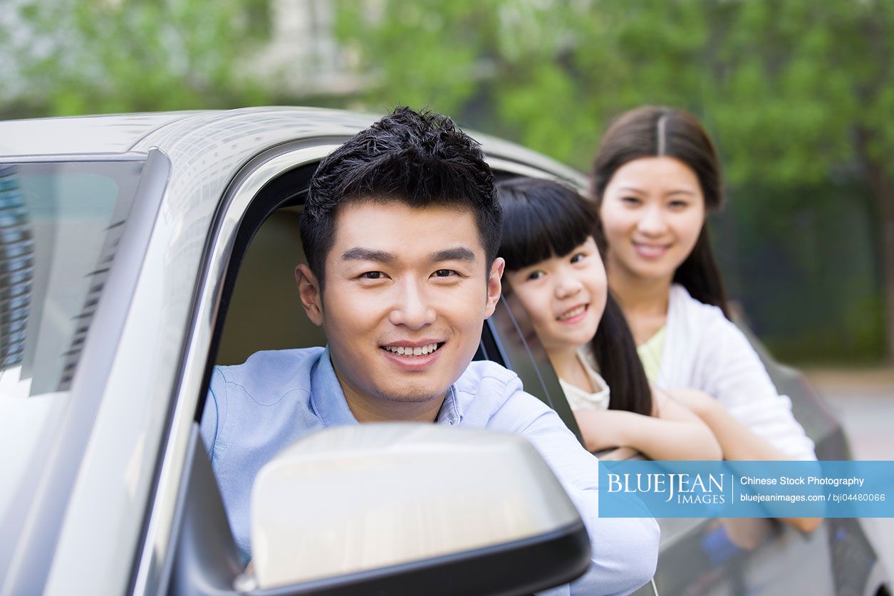 Happy young Chinese family in a car