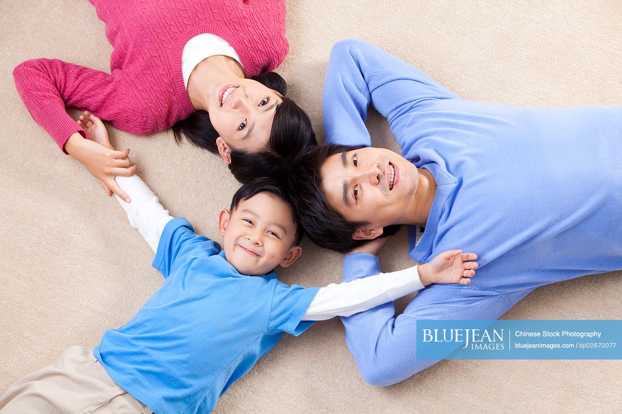 Young Chinese family lying on the floor