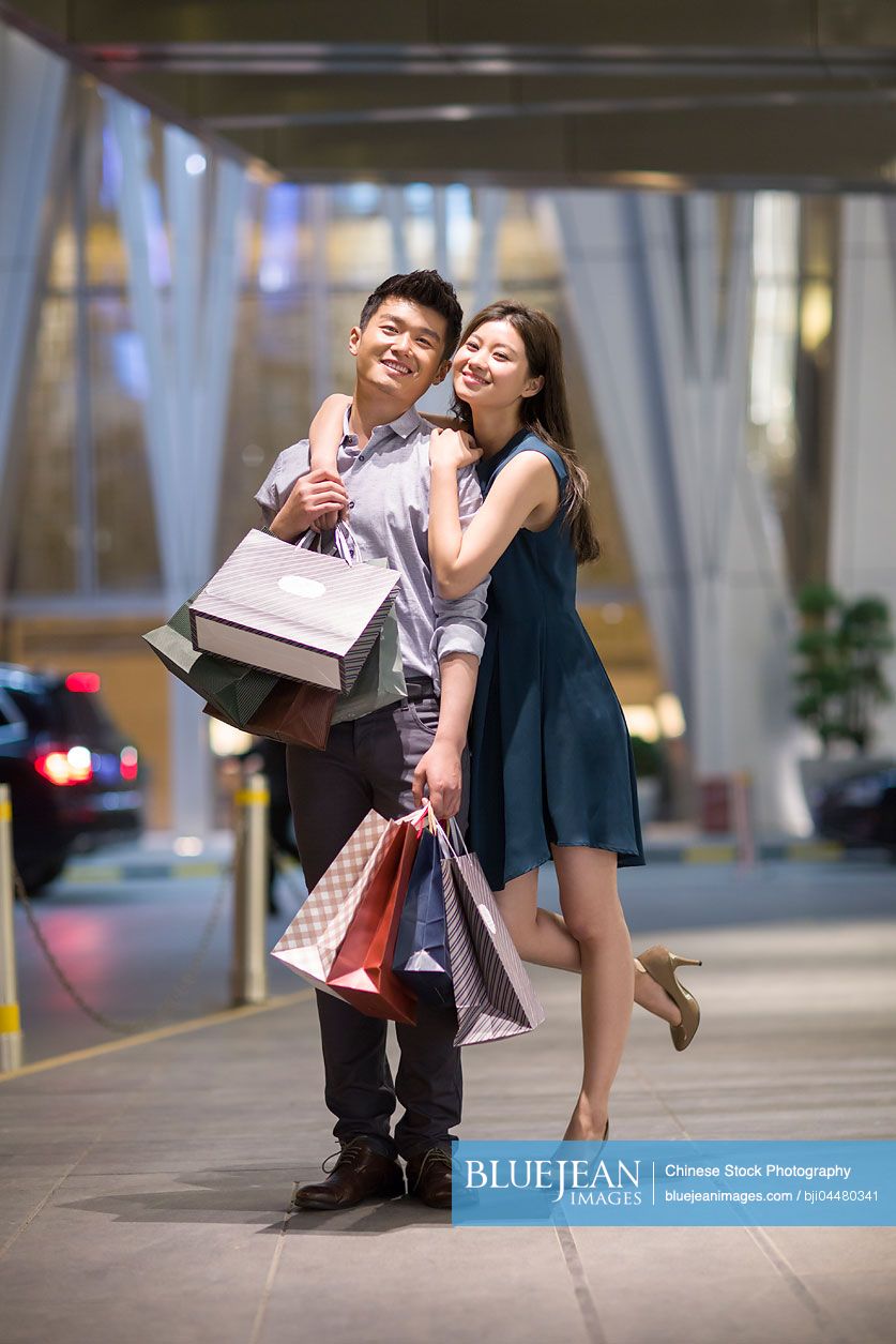 Happy young Chinese couple shopping