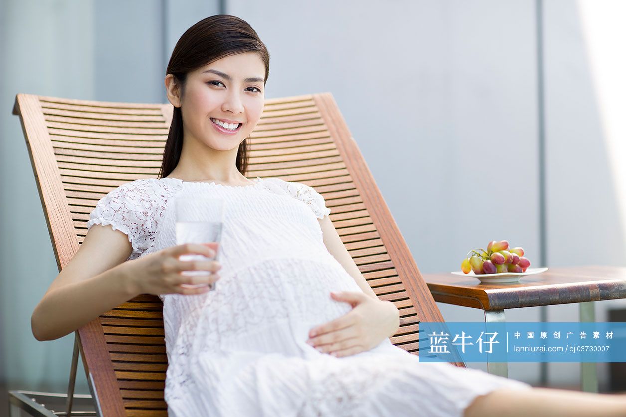 孕妇靠在躺椅上喝水