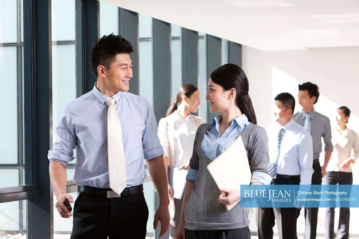 Chinese businesspeople discussing matters in a hallway