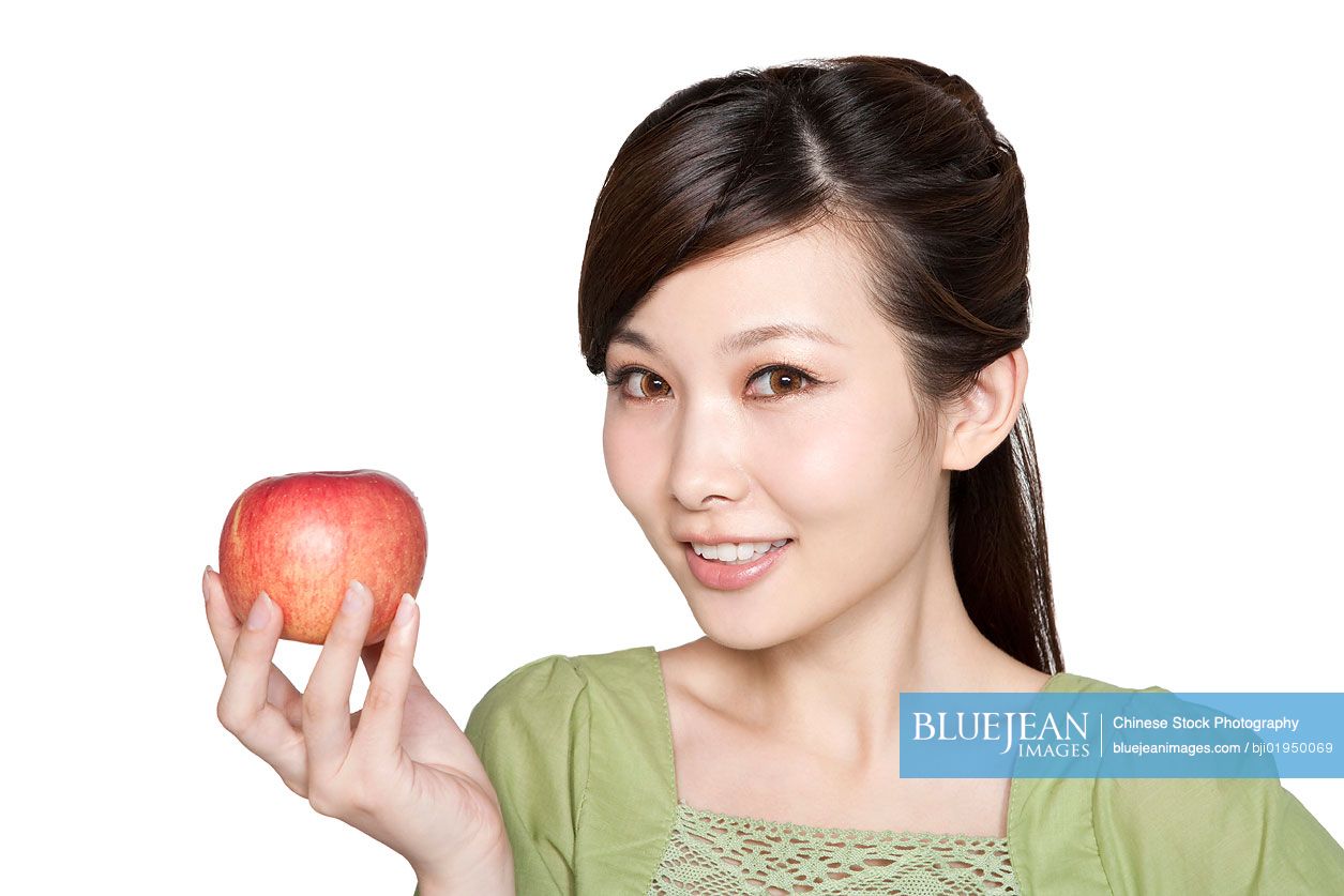 Portrait of young Chinese woman with red apple