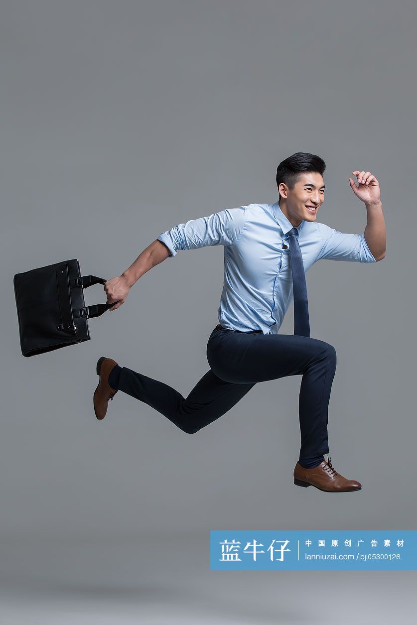 快乐的年轻商务男子拎着公文包奔跑