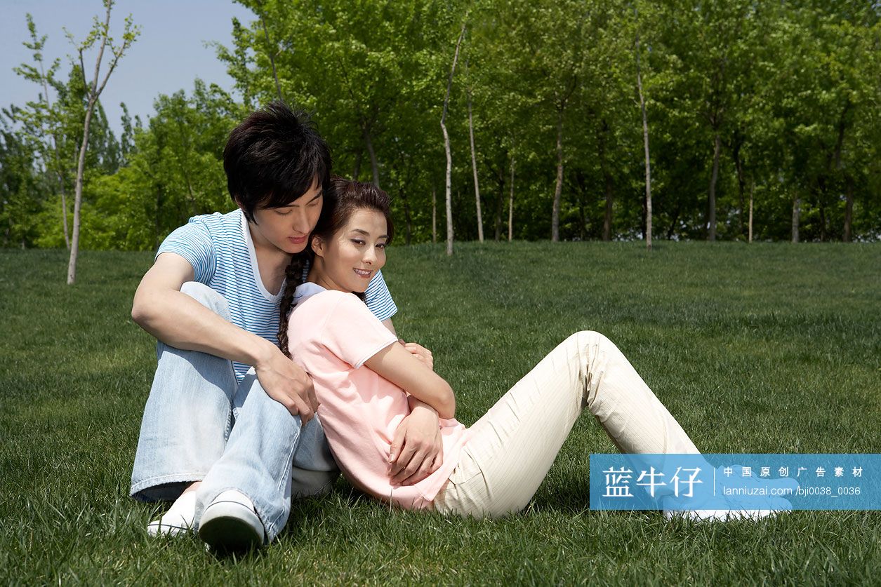 年轻情侣坐在草地上