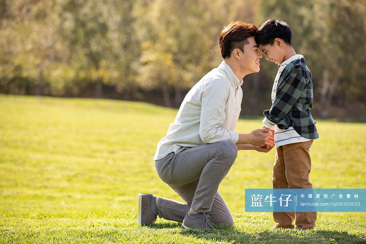 快乐的的父子俩在草地上玩耍