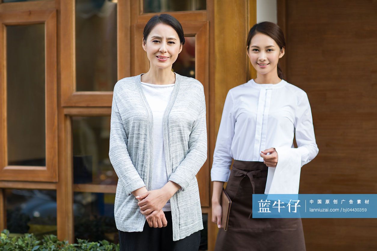 餐厅老板和服务员站在店门口