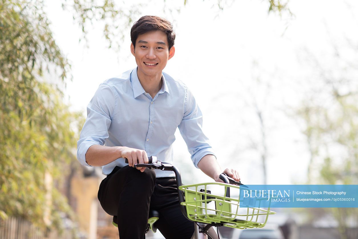 Young Chinese man riding a share bike