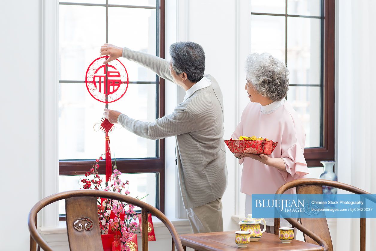 Senior couple decorating their house for Chinese New Year