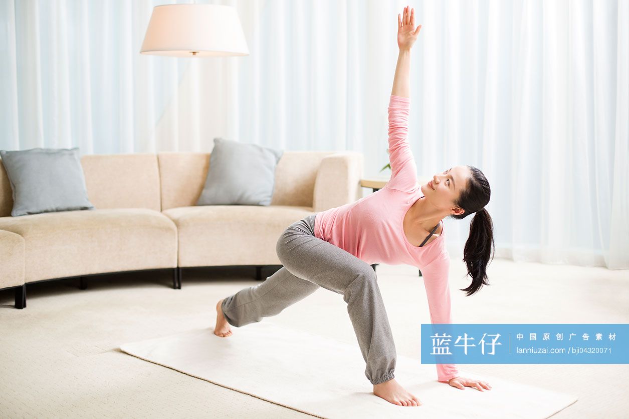 年轻女子在客厅练习瑜伽