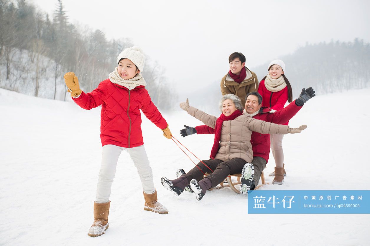 快乐的一家人在雪地上玩雪橇