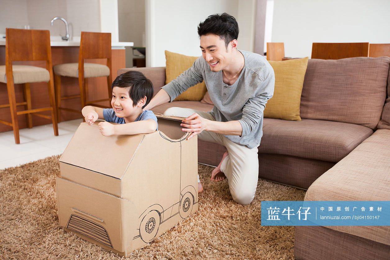 父子俩在客厅里面玩纸箱做的车子