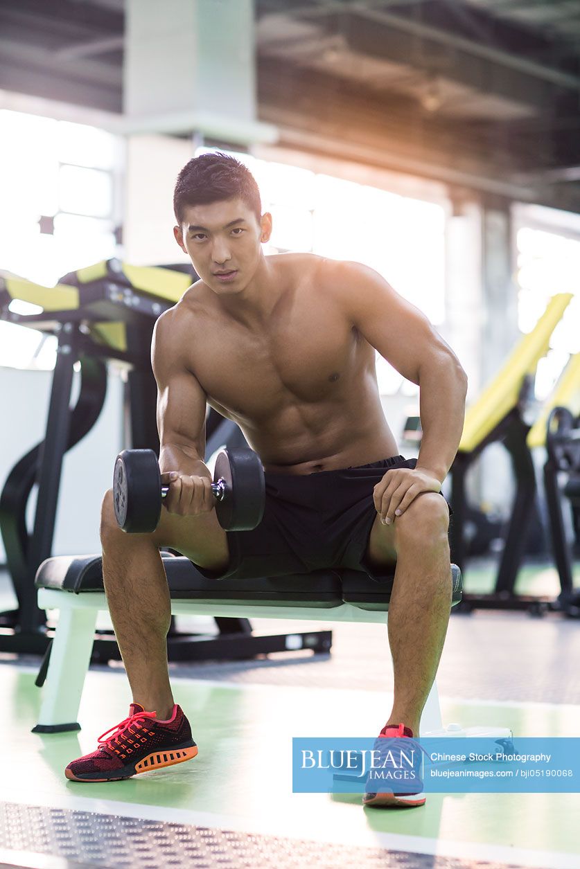 Young Chinese man exercising at gym