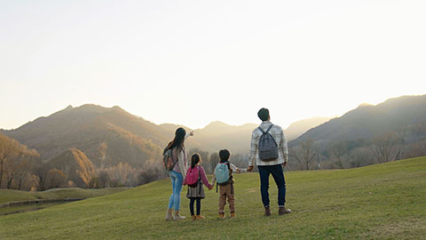 Happy young Chinese family hiking outdoors