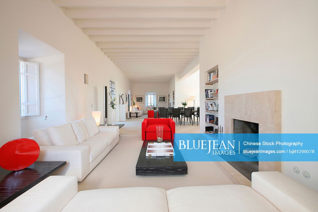 Modern white living room with red chair