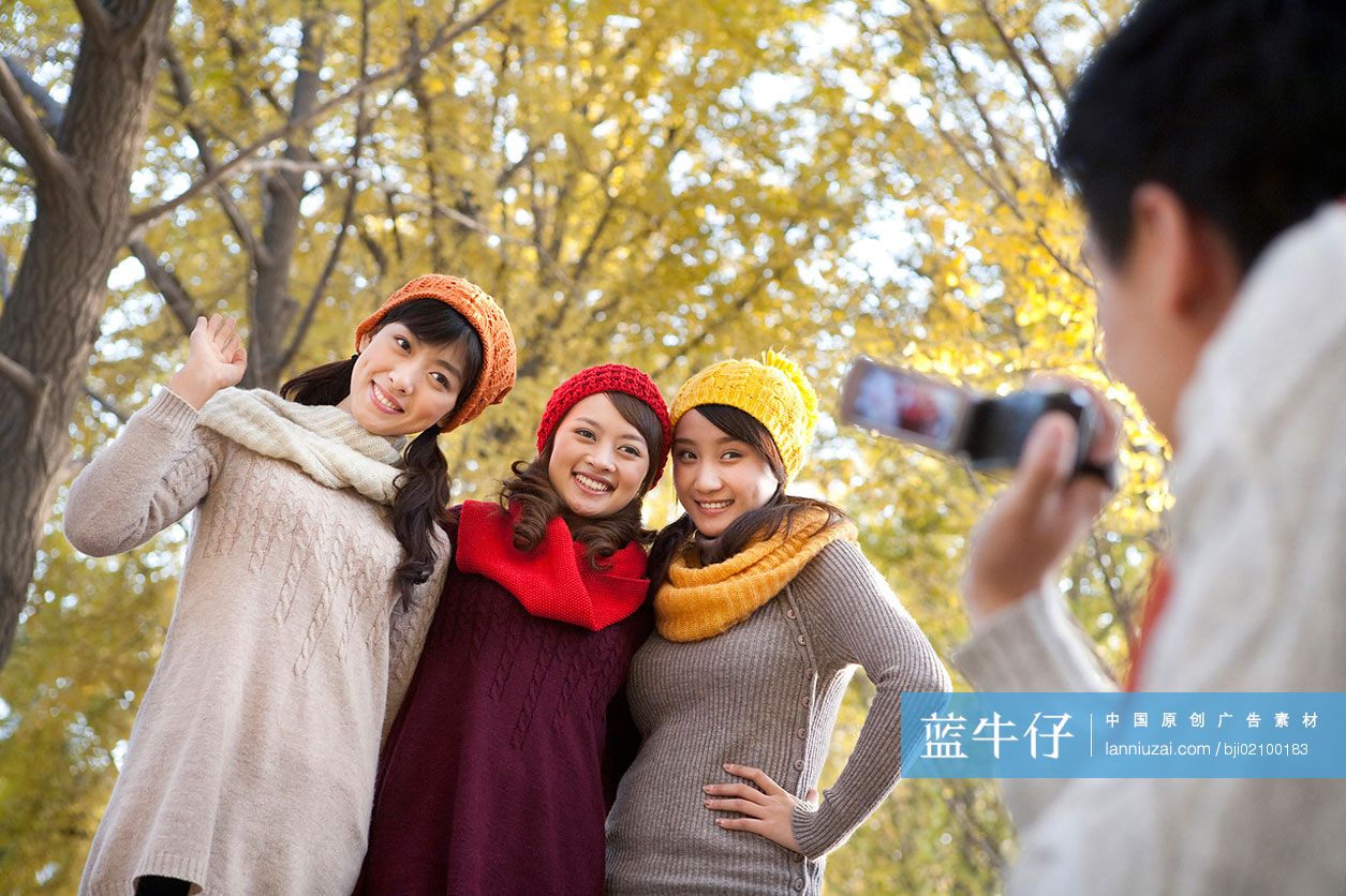 年轻人在秋日午后树林拍照