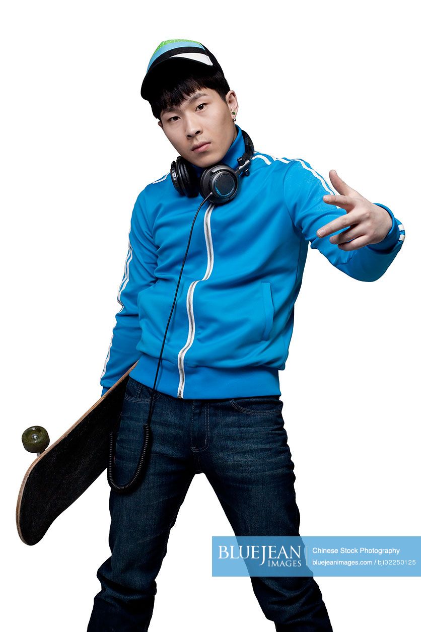 Hip young Chinese man posing with Skateboard